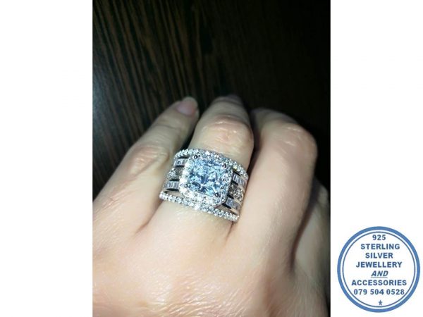 925 Sterling Silver Statement Designers Ring. 2 Baguette middle rows around center twirls and side cubic detail with large Halo Square Clear Cubic